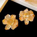 Detailed macro view of elegant gold metallic wrinkled flower stud earrings for women - Pleated Flower Shape / Gold