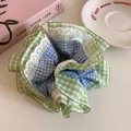 Detailed view of a green and blue gingham scrunchie featuring elegant white lace trim - Blue Checkered - Green Edge
