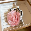 Close-up of pink fabric rose hair scrunchie with pearl charm and ruffled band - Pink