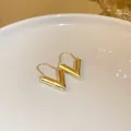 Detaillierte Nahaufnahme von minimalistischen goldfarbenen Ohrringen im stilvollen V-Design. - Buchstabe V-Form Stil (8#)