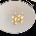 Detailansicht von strukturierten goldenen Kugelohrringen auf einer Spiegeloberfläche - Gebürsteter Sphärischer Ohrhakenstil (5#)