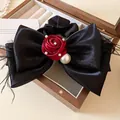 Elegant black satin oversized bow hair scrunchie with red fabric rose and pearl accents. - Black