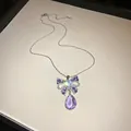 Detailansicht einer luxuriösen Halskette mit glitzerndem Schleifenanhänger und lila Tropfen. - Lila Schleifen Halskette (WN1254) / Silber