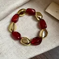 Dettaglio delle perle rosse glitterate e dorate su un bracciale elastico vintage - Bracciale / Rosso