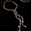 Elegant sparkling rhinestone tassel necklace with round geometric drop detail on black - Tassel Necklace / Gold