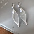 Vista ravvicinata di orecchini a nappa in maglia d'argento con perle bianche eleganti - Stile Maglia con Nappina Lunga / Argento