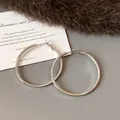 Close-up detail of large silver hoop earrings with elegant polished finish. - Medium (HE23305) / Diameter 45mm / Silver