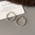 Close-up of minimalist silver round hoop earrings on a textured background with a quote card. - Small (HE23305) / Diameter 29mm / Silver