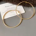 Detailed view of large gold hoop earrings with minimalist stainless steel design. - Large (HE23305) / Diameter 69mm / Gold