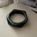 Detalle de un brazalete minimalista de acrílico negro con un diseño geométrico único. - Estilo Hexagonal / Negro