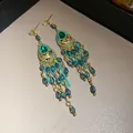 Vintage Palastohrringe mit grünen Kristallen und eleganten Tropfenquasten für Damen. - Grün