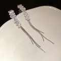 Dettaglio ravvicinato di orecchini a nappa in argento con pietre di zircone quadrate - Stile Nappina Quadrata Irregolare (HE15654) / Argento