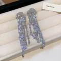 Macro view of luxury cubic zirconia tassel earrings with silver needles in a jewelry tray - Silver-White