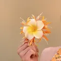 Elegant frangipani flower hair clip with vibrant orange petal accents for beach vacations. - Duckbill Clip (24#) / Orange