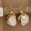 Close-up of zircon and white shell tassel earrings with gold hoops for beach style - Gold and White