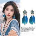 Detaillierte Ansicht von böhmischen blauen Federohrringen an einem asiatischen Model. - Orhaken - Blaue Feder
