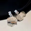 Primo piano di eleganti orecchini a petalo in metallo spazzolato con pietre di zircone - Goccia di Petalo Grande / Argento