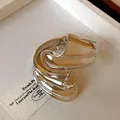 Macro view of punk style irregular wavy silver metallic cuff bracelet with high gloss finish - Silver