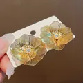 Vista dettagliata di squisiti orecchini a fiore in filo placcato oro con centri in zircone - Stile Fiore Placcato Oro Vero / Oro