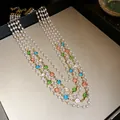 Close-up of multi-layer French vintage necklace with pearls and colorful round gemstones. - Gold