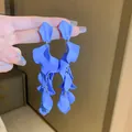 Vista dettagliata degli orecchini pendenti a petalo blu Klein con finitura opaca - Orecchini a Pendente con Nappine di Petali Multistrato Opachi / Blu Klein