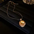 Détail d'un collier vintage français avec grande perle dorée et niveaux en zircon - Or