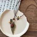 Détail d'un collier ethnique bohème avec plume en bronze et breloque étoile dorée - Collier (2#)