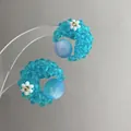 Detailed view of handmade blue beaded flower stud earrings with a tiny white floral accent - Blue Transparent Flower Moon (HE13022) / Blue