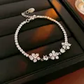 Élégant bracelet tennis en zircone argentée avec trois grappes de fleurs scintillantes à cinq pétales - Style Fleur / Argent