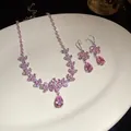 Set di gioielli in zircone rosa con pendenti a fiore e goccia su piatto bianco ceramica. - Set Collana E Orecchini / Argento-Rosa