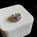 Detail shot of a multi-layer silver ring with pavé zircons on a white jewelry gift box - Multi-layer Geometric Style (HR769) / Silver