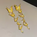 Macro view of vintage gold butterfly tassel earrings featuring intricate crystal accents - Gold Butterfly Rhinestone Tassel