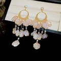 Close-up of elegant gold tassel earrings with pink shell petals and white pearls - Pink Shell Petal Pearl Tassel