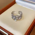 Detailed view of silver 18k gold plated ring with pearls and zircons in a jewelry box. - Wave Layered Open Design / Adjustable Open / Silver