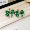 Elegant green resin bow earrings with sparkling rhinestone trim and gold stud detail - Green