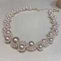 Primo piano di un elegante girocollo di perle bianche con catena d'oro regolabile - Collana di Perle Intrecciate a Onde 6#