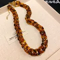 Detail view showing the tortoiseshell resin texture of a chunky chain statement necklace - Necklace / Gold Dark Brown