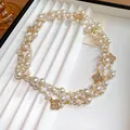 Dettaglio di una collana di perle a più fili con ciondoli a fiore di diamanti stile vintage - Bianco