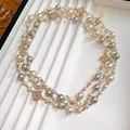 Dettaglio squisito di elegante collana di perle a più fili con ciondoli a quadrifoglio. - Bianco Sporco
