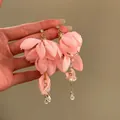 Dettaglio ravvicinato di orecchini a fiore in tessuto rosa con strass e perle di tendenza - Stile 41# / Ago d'argento / Oro-Rosa