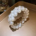 Close-up shot of an elegant three-row pearl bracelet featuring sparkling rhinestone accents - 3-Layer Bracelet / Silver
