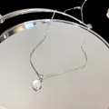 Detailed close-up of minimalist round resin pendant necklace on a reflective mirror - Choker Necklace / Silver