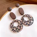 Close-up of wooden stud earrings with leopard print acrylic ring pendants - Silver Post - Coffee - Medium / Medium / Brown