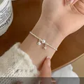 Korean style silver beaded bracelet featuring a white pearl and starfish charm on wrist - Silver