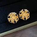 Detailed macro view of 18k gold plated flower cluster ear clips on a black velvet display - Flower Cluster Style Ear Clip / Gold