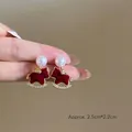 Gros plan détaillé des boucles d'oreilles cheval à bascule en velours et perles - Style Poney Floqué Rouge avec Perle (1#)