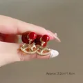 Gros plan de boucles d'oreilles cheval à bascule doré, perles rouges et zircons - Style Cheval à Bascule Doré avec Perle Rouge (3#)