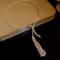 Macro view of a sparkling zircon tassel necklace with intricate gold rhinestone details - Long Tassel Choker / Gold