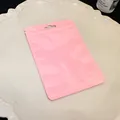 Close-up detail of a pink macaron resealable storage bag on a cream ceramic plate - Plastic Self-Sealing Bag / Pink