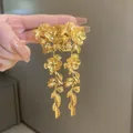 Close-up of elegant gold-toned floral drop earrings with delicate leaf tassel detail - Gold Flower Leaf (44#)